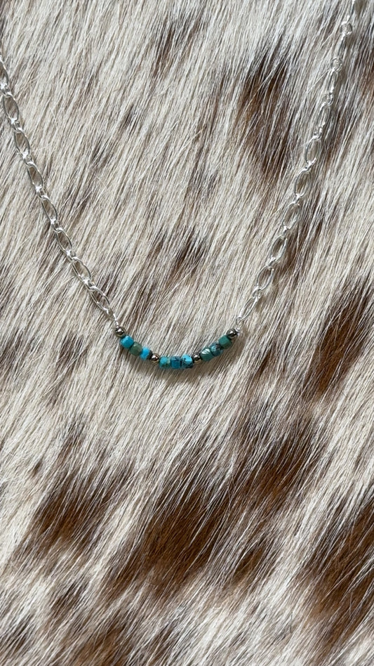 Dainty Sterling chain necklace with a turquoise bead bar pendant. It incorporates genuine turquoise nuggets featuring accents of small silver beads.