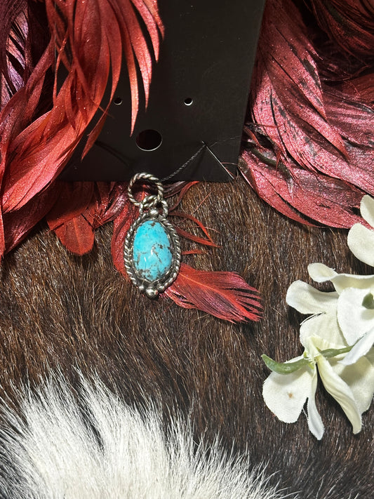 Sterling silver pendant featuring a genuine, highly matrixed turquoise stone.